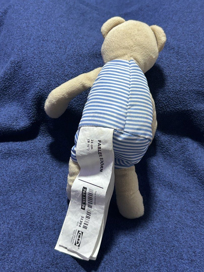 IKEA FABLER BJÖRN soft toy (Category: Plushies & Soft Toys) located in Angeles City. Submitted by zyeplustradings (Listing ID 1432322280, Image 2). Description: IKEA FABLER BJÖRN soft toy Item: Plush teddy bear with a blue striped romper and a red heart appliqué. Dimensions: Approximately 21 cm (8 inches) in height. Design: Features contrasting colors and soft materials, designed for hugging, comforting, and play. Safety: Child-safe construction 