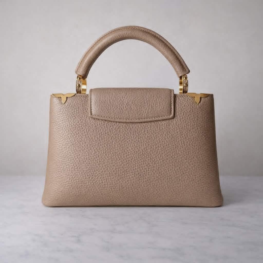 Louis Vuitton Capucines BB Beige Top Handle Bag (Category: Luxury Bags & Wallets) located in Cebu City. Submitted by theluxxaffair (Listing ID 1432372053, Image 2). Description: Louis Vuitton Capucines BB in beige Taurillon leather. A structured top handle bag featuring the signature LV flap closure with gold hardware and the iconic Capucines flower detailing along the top edge. Designed to be carried by hand with the option for shoulder or cross