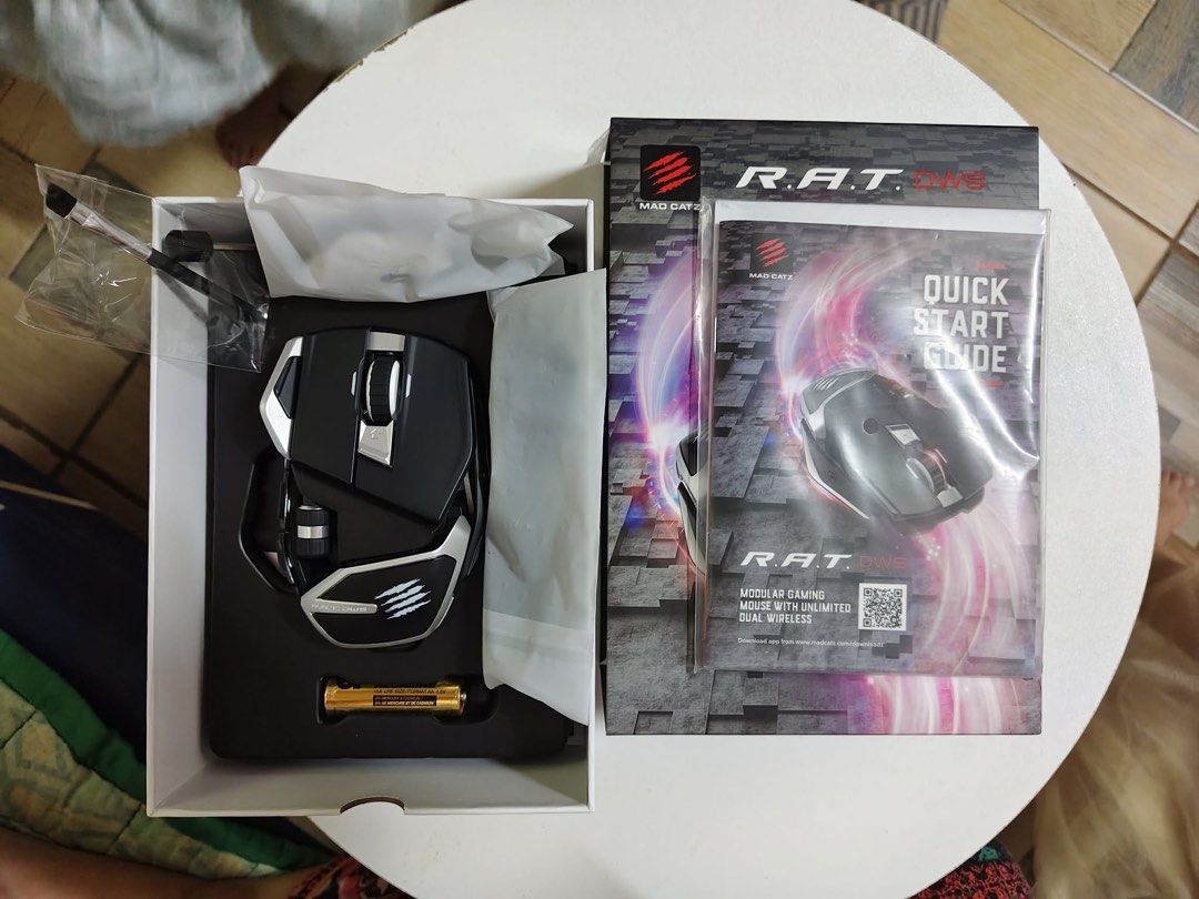 Mad Catz R.A.T. DWS Modular Gaming Mouse (Category: Mouse & Mousepads) located in Quezon City. Submitted by breezynem (Listing ID 1432219520, Image 2). Description: - Mad Catz R.A.T. DWS gaming mouse - Dual wireless connectivity - Includes: Mouse, accessories, and AA battery - Unique, adjustable design - Box with Mad Catz logo and product info.