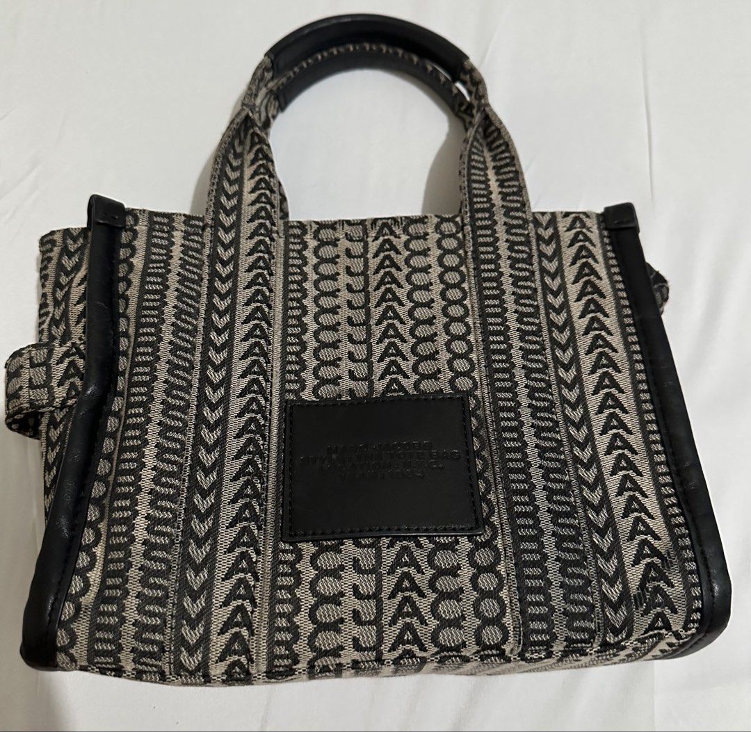 Marc Jacobs The Tote Bag (Category: Luxury Bags & Wallets) located in Cagayan de Oro. Submitted by aquamarine14 (Listing ID 1432283322, Image 2). Description: - Marc Jacobs The Tote Bag - Black and beige jacquard design - Two top handles - Adjustable, detachable shoulder strap - Main compartment with zipper closure - Silver-toned hardware -check photos for flaws .