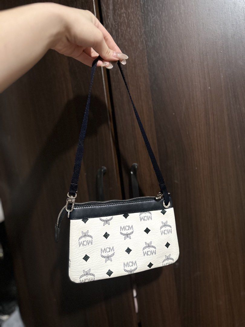 MCM Visetos Etui Pochette Mini Bag (Category: Luxury Bags & Wallets) located in Iloilo. Submitted by quailgunzone (Listing ID 1432349324, Image 1). Description: - Authentic MCM Visetos Etui Pochette mini bag - Iconic MCM logo print on white canvas - Black leather trim - Detachable black strap - Silver zipper and hardware - Compact, small size - Perfect for essentials 9.8/10 Condition.