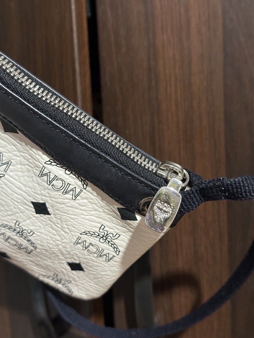 MCM Visetos Etui Pochette Mini Bag (Category: Luxury Bags & Wallets) located in Iloilo. Submitted by quailgunzone (Listing ID 1432349324, Image 2). Description: - Authentic MCM Visetos Etui Pochette mini bag - Iconic MCM logo print on white canvas - Black leather trim - Detachable black strap - Silver zipper and hardware - Compact, small size - Perfect for essentials 9.8/10 Condition.