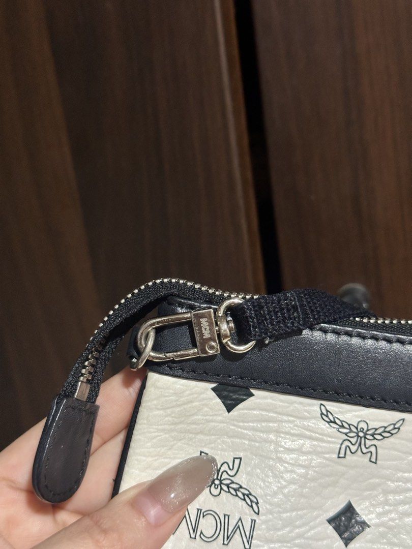 MCM Visetos Etui Pochette Mini Bag (Category: Luxury Bags & Wallets) located in Iloilo. Submitted by quailgunzone (Listing ID 1432349324, Image 3). Description: - Authentic MCM Visetos Etui Pochette mini bag - Iconic MCM logo print on white canvas - Black leather trim - Detachable black strap - Silver zipper and hardware - Compact, small size - Perfect for essentials 9.8/10 Condition.