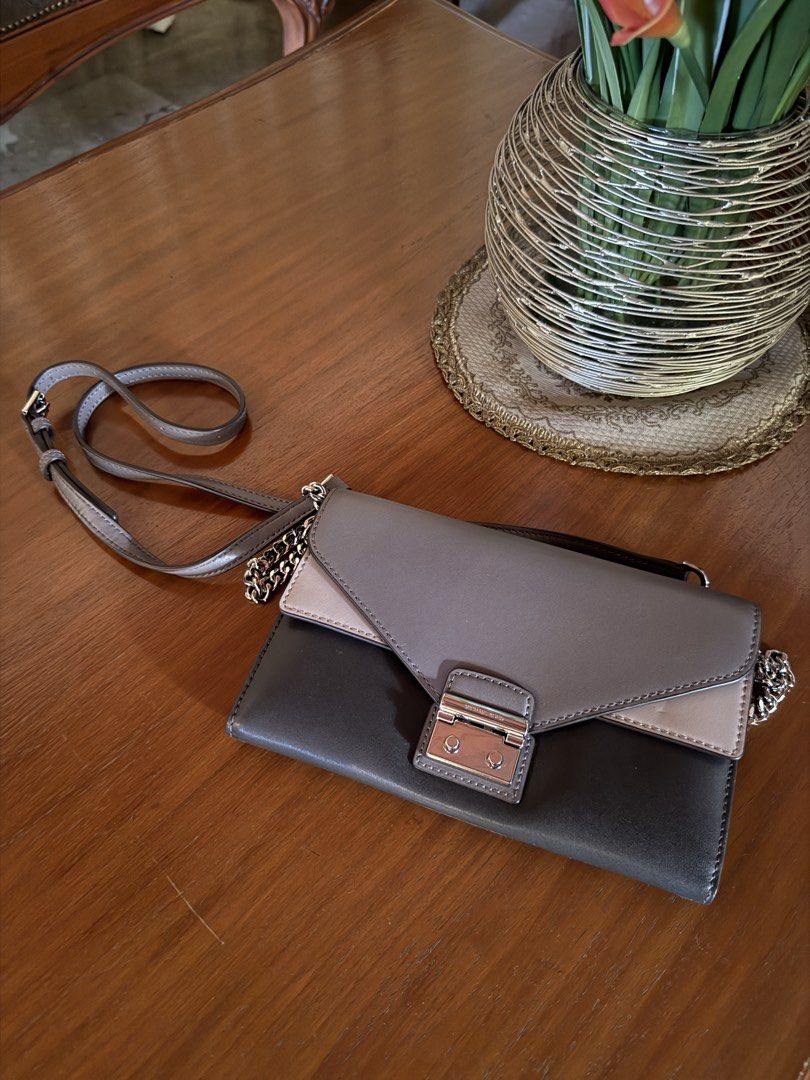 Michael Kors Clutch Bag (Category: Luxury Bags & Wallets) located in Lubao. Submitted by xpatriziam (Listing ID 1432282491, Image 3). Description: - Michael Kors clutch bag - Multi-tone design (gray, beige, black) - Silver chain strap - Secure clasp closure - Interior: multiple compartments, zippered pocket - Perfect for essentials - Elegant and stylish.