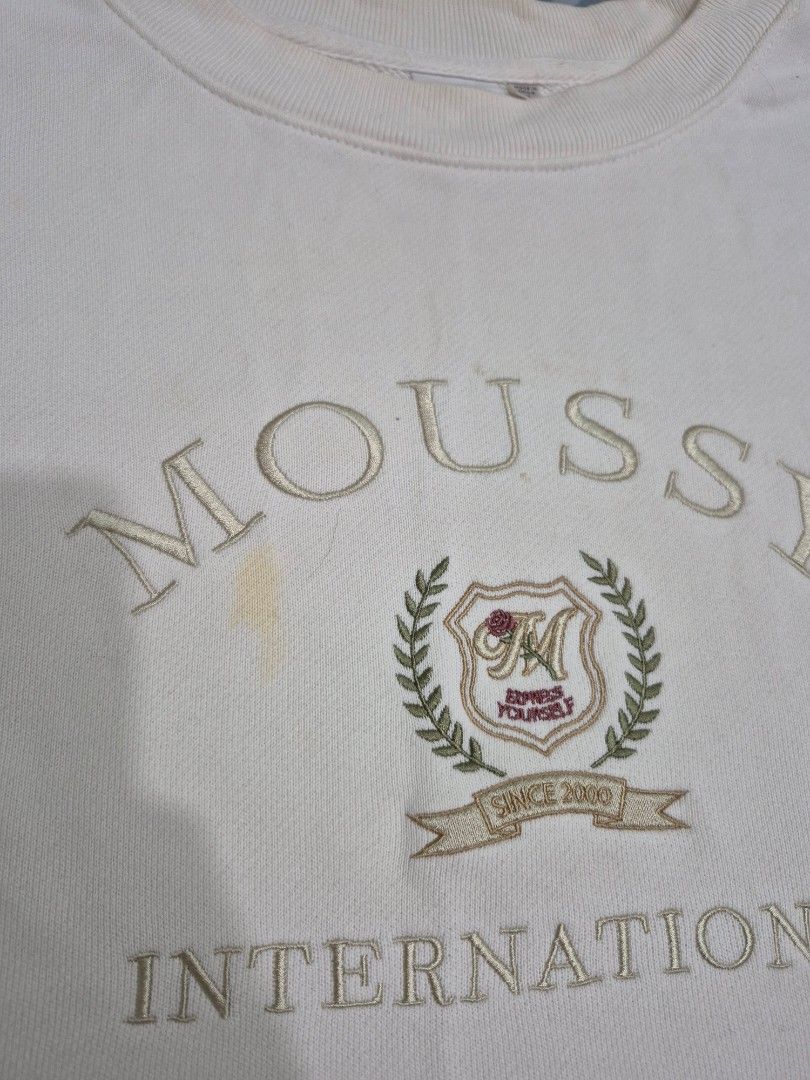 Moussy International Sweatshirt (Category: Longsleeves) located in Taguig. Submitted by dthrift9 (Listing ID 1432226187, Image 2). Description: - Cream-colored Moussy International sweatshirt - Size: P - Features embroidered "MOUSSY INTERNATIONAL" logo - Crew neck and long sleeves - Made in China - Measurements available in photos.