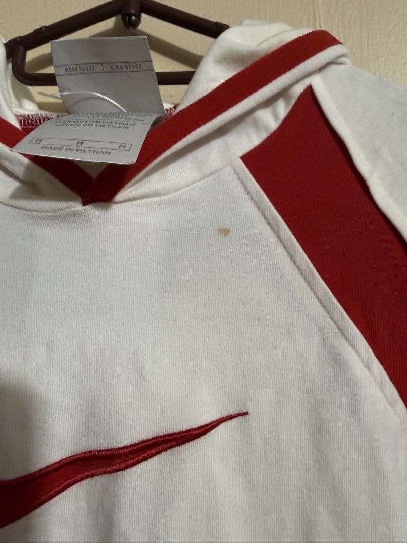 Nike White and Red Hoodie (Category: Coats, Jackets and Outerwear) located in Quezon City. Submitted by lau_v (Listing ID 1432377086, Image 3). Description: - White Nike hoodie with red accents - Features Nike logo - Hooded with long sleeves - Red cuffs - Size: M on tag but fits S (body hugging) With stain shown on photo.