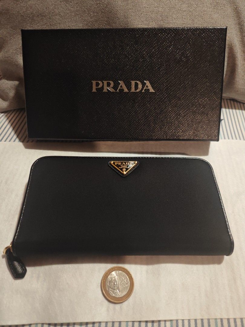 Prada Black Zip Around Wallet (Category: Luxury Bags & Wallets) located in Caloocan City. Submitted by rijentolio24393 (Listing ID 1432344106, Image 2). Description: - Authentic Prada wallet - Black color - Gold-tone Prada logo - Includes box and authenticity cards - Multiple compartments - Zip closure.