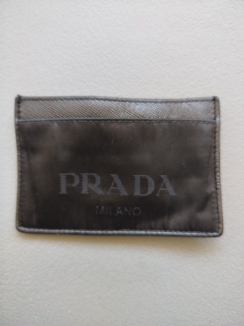 Prada Card Holder (Category: Luxury Bags & Wallets) located in Calamba. Submitted by merrymerida (Listing ID 1432290302, Image 1). Description: - Authentic Prada card holder - Color: Black - Features Prada logo and "MILANO" - Textured back design - Interior with card compartments - "MADE IN ITALY" marked.