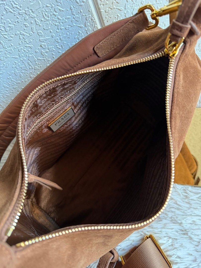 Preloved Prada Suede Hobo Bag (Category: Luxury Bags & Wallets) located in Manila. Submitted by bagsandshoesmanymore (Listing ID 1432353181, Image 3). Description: - Authentic Prada hobo bag - Brown suede exterior - Gold-tone hardware - Zip closure - Detachable shoulder strap - Two exterior pockets with buckle details - Interior zip pocket - Prada logo tag - 'riri' zipper Please read before you order 👉🏻❗️Payment first before shipping ❗️Cut off 