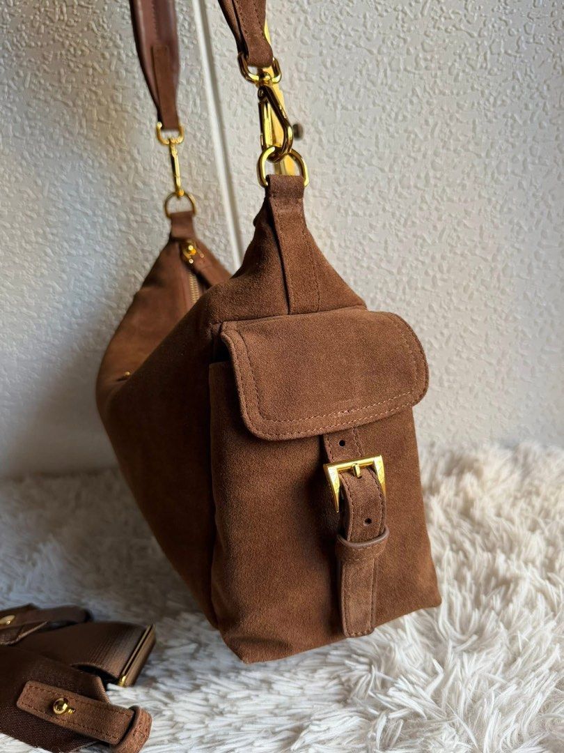 Preloved Prada Suede Hobo Bag (Category: Luxury Bags & Wallets) located in Manila. Submitted by bagsandshoesmanymore (Listing ID 1432353181, Image 2). Description: - Authentic Prada hobo bag - Brown suede exterior - Gold-tone hardware - Zip closure - Detachable shoulder strap - Two exterior pockets with buckle details - Interior zip pocket - Prada logo tag - 'riri' zipper Please read before you order 👉🏻❗️Payment first before shipping ❗️Cut off 