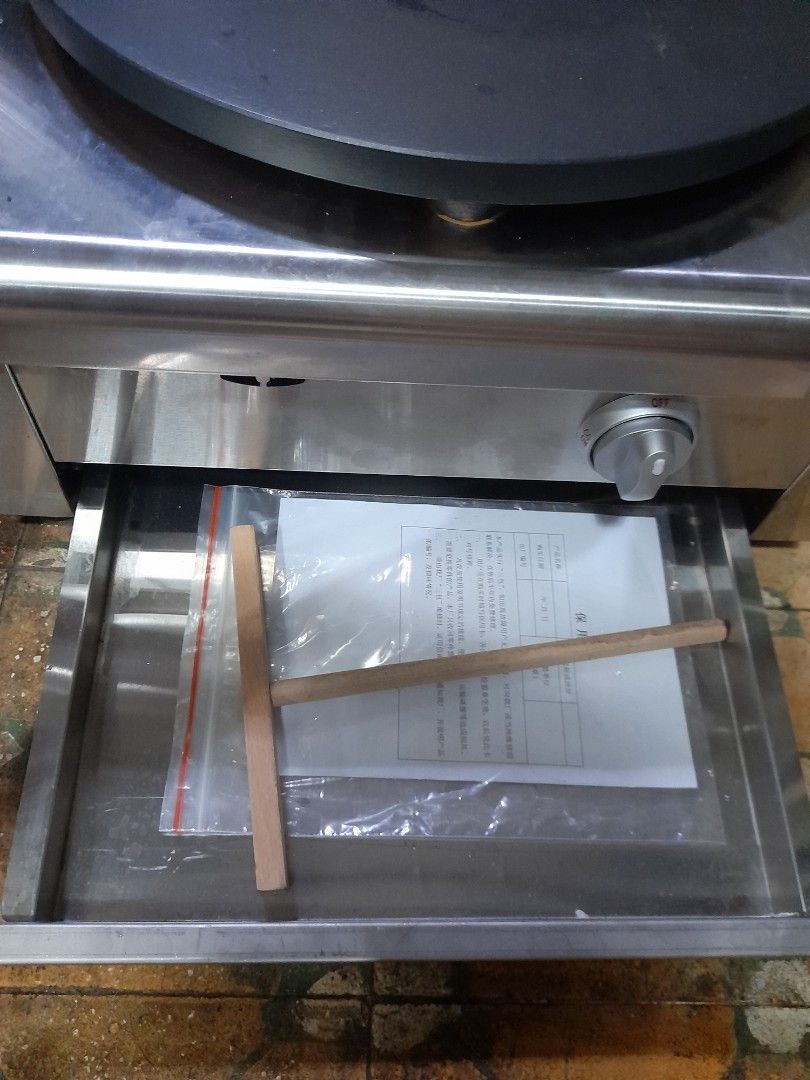 Stainless Steel Crepe Maker (Category: Other Kitchen Appliances) located in Valenzuela. Submitted by newbear.425b6e (Listing ID 1432227950, Image 3). Description: - Stainless steel crepe maker - Large, circular cooking surface (approx. 16 inches diameter) - Features a storage drawer - Includes a control knob - Comes with a wooden spreader and other accessories - Unit is in good working condition -bago p po hindi nagamit de gas po.