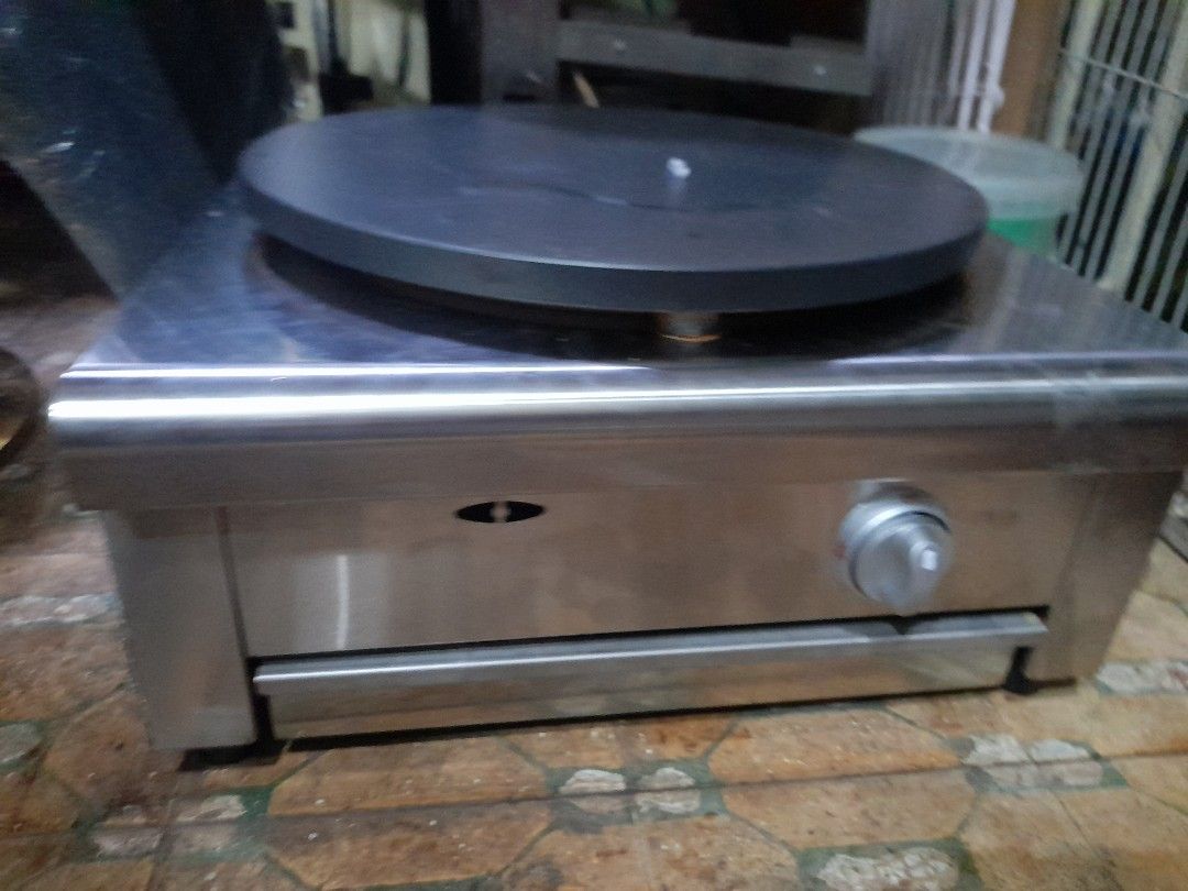 Stainless Steel Crepe Maker (Category: Other Kitchen Appliances) located in Valenzuela. Submitted by newbear.425b6e (Listing ID 1432227950, Image 2). Description: - Stainless steel crepe maker - Large, circular cooking surface (approx. 16 inches diameter) - Features a storage drawer - Includes a control knob - Comes with a wooden spreader and other accessories - Unit is in good working condition -bago p po hindi nagamit de gas po.