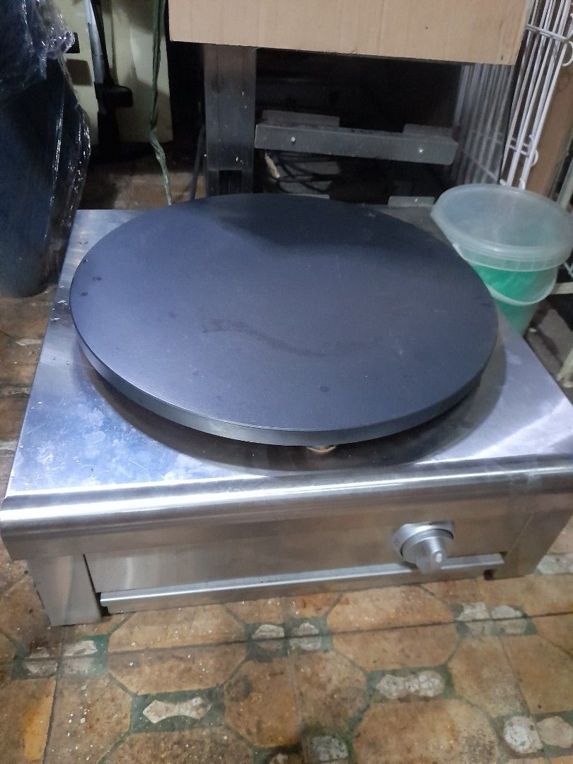 Stainless Steel Crepe Maker (Category: Other Kitchen Appliances) located in Valenzuela. Submitted by newbear.425b6e (Listing ID 1432227950, Image 1). Description: - Stainless steel crepe maker - Large, circular cooking surface (approx. 16 inches diameter) - Features a storage drawer - Includes a control knob - Comes with a wooden spreader and other accessories - Unit is in good working condition -bago p po hindi nagamit de gas po.