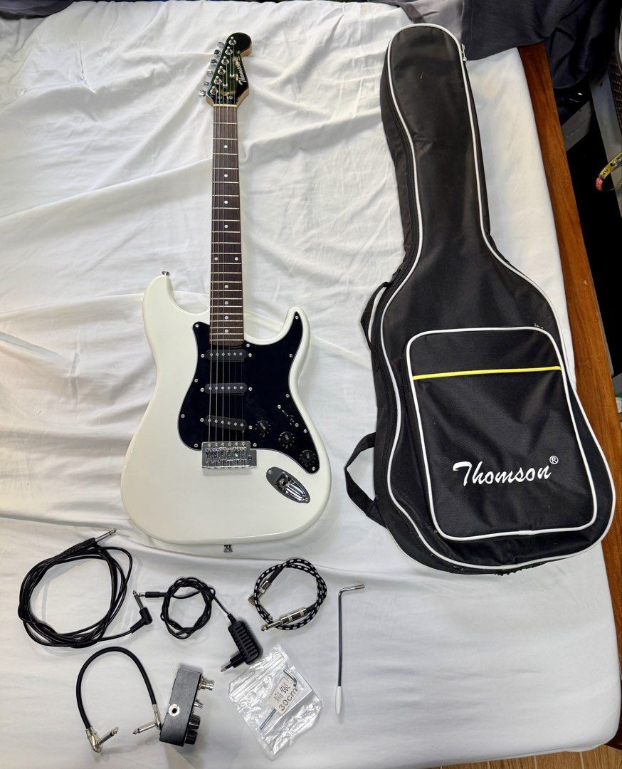Thomson Electric Guitar with Accessories (Category: Musical Instruments) located in Binan City. Submitted by mrpoor (Listing ID 1432290414, Image 1). Description: Physical Description Color: White with Black Pickguard Variant Body: Solid Ash Wood Neck: Maple Fingerboard: Rosewood Neck Pickup: Thomson Single coil Middle Pickup: Thomson Single coil Bridge Pickup: Thomson Single coil Controls: 1Volume, 2Tone, 3-Way Switch Number of frets: 22 Pickgua
