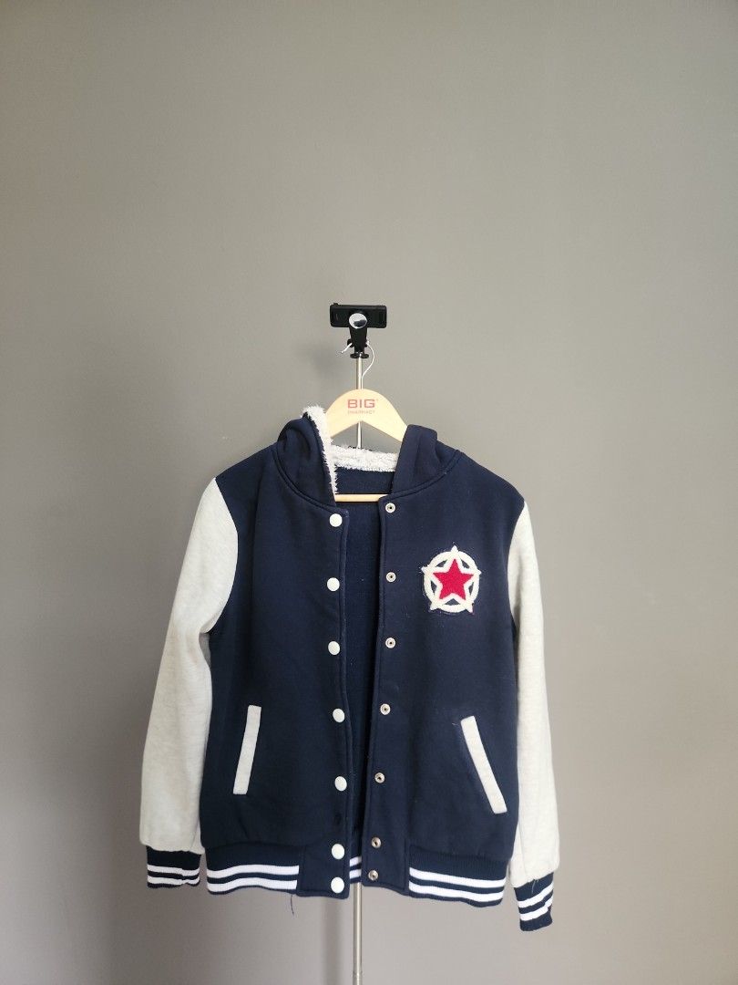 Varsity Jacket with Star Patch (Category: Coats, Jackets and Outerwear) located in Kuala Lumpur. Submitted by wwear (Listing ID 1432246237, Image 1). Description: - Navy blue varsity jacket - Light grey sleeves - Star patch on chest - White stripes on sleeves and hem - Hooded - Button closure - Soft lining - Perfect for casual wear.