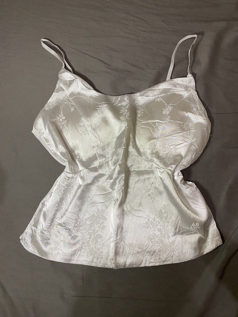 White Floral Camisole (Category: Sleeveless) located in Manila. Submitted by dodoheeee (Listing ID 1432338197, Image 1). Description: - White camisole with floral pattern - Features spaghetti straps - Slightly flared bottom - Made of silky material - Subtle sheen and delicate design - Perfect for layering - Versatile wardrobe piece.