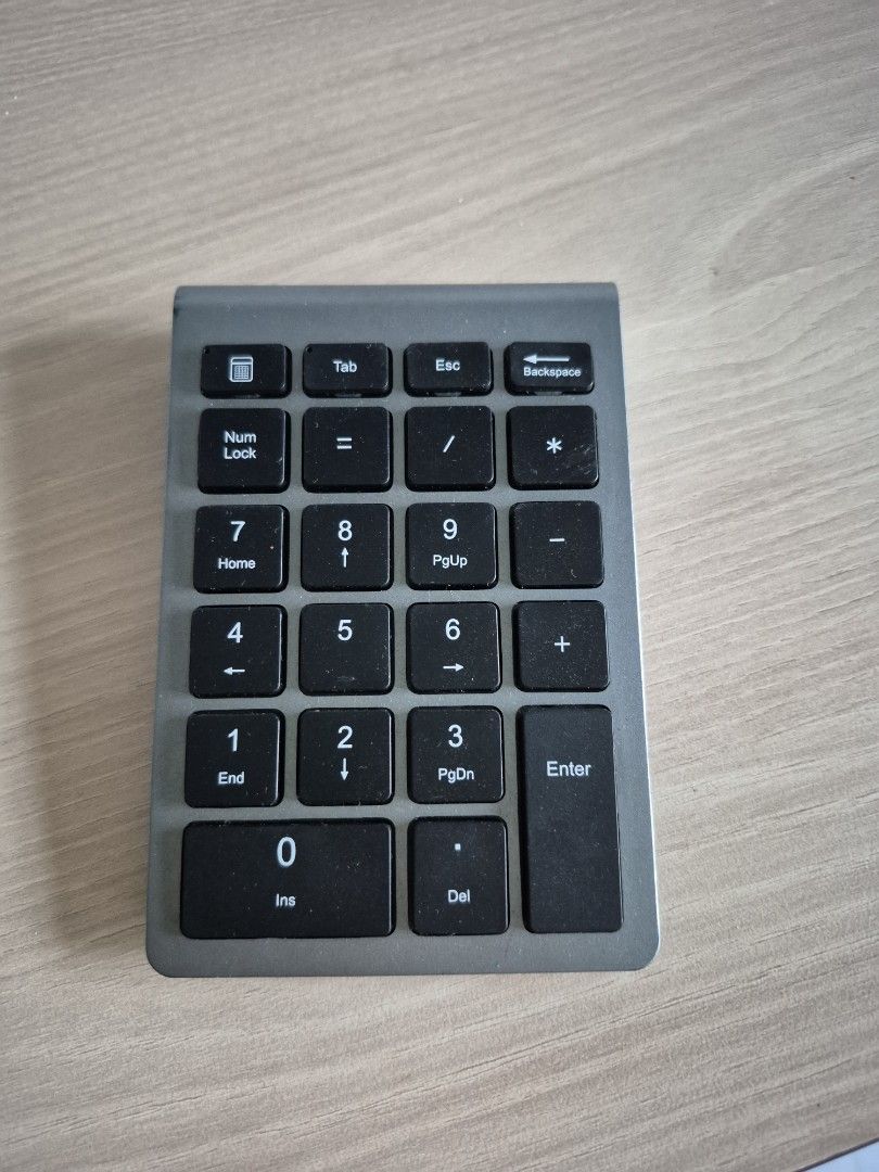 Wireless Numeric Keypad (Category: Computer Keyboard) located in Singapore. Submitted by nishiki2221 (Listing ID 1432300713, Image 1). Description: - Wireless numeric keypad - Grey finish with black keys - Model: RF304 - Includes backspace and function keys - Features a power switch.