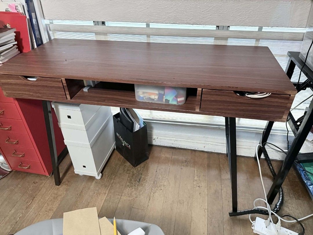 Wooden Desk with Drawers (Category: Tables & Sets) located in Manila. Submitted by happy.twinstars (Listing ID 1432203228, Image 3). Description: - Dark brown wooden desk - Features two drawers and an open shelf - Rectangular tabletop - Black metal legs - Sturdy construction - Sturdy wood - Perfect for home office or study - Provides ample workspace and storage Size: Height: 27 inches Width: 46.5inches Length: 16 inches pick up locatiom: Sta. Mes