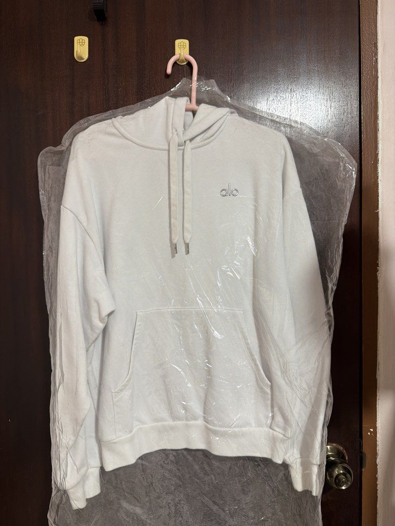 Alo Yoga White Hoodie (Category: Activewear) located in Singapore. Submitted by xdaintydaisies (Listing ID 1432568849, Image 1). Description: - White Alo Yoga hoodie - Classic kangaroo pocket - Drawstring hood - Perfect for everyday wear and workouts - Kept in a garment bag Has some fuzz on the sweater but i think easily removable with a fabric shaver. .