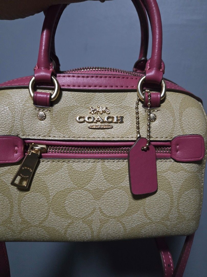 Coach Mini Rowan Bag (Category: Luxury Bags & Wallets) located in Bulacan. Submitted by row01 (Listing ID 1432558464, Image 3). Description: - Coach Mini Rowan Bag - Signature logo pattern with pink accents - Top handle and detachable shoulder strap - Zip closure - Interior pocket - Deep pink interior lining - Gold-toned hardware.