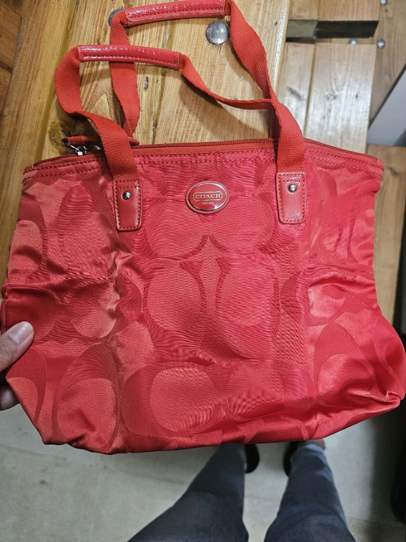 Coach Red Tote Bag (Category: Luxury Bags & Wallets) located in Antipolo. Submitted by janelleiri03539 (Listing ID 1432395945, Image 1). Description: - Red Coach tote bag - Top zipper closure - Double handles - Repeating Coach logo pattern - Darker red accents - Nylon-like material.