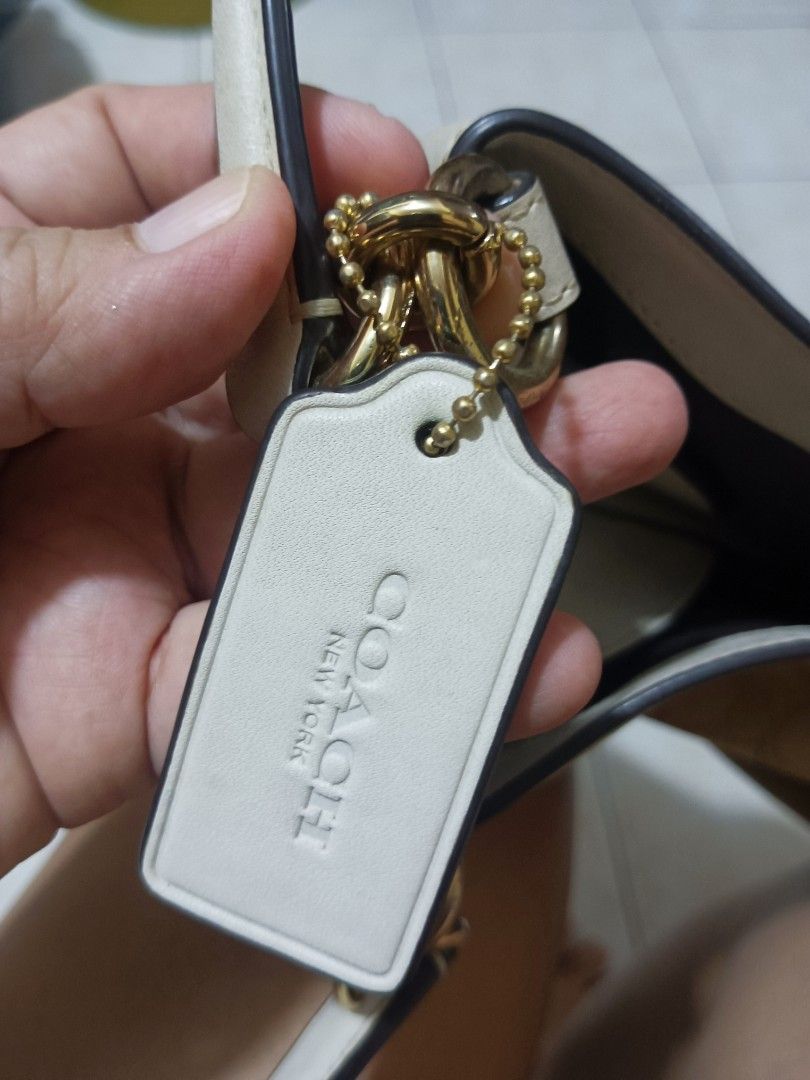 Coach Signature Shoulder Bag (Category: Luxury Bags & Wallets) located in Bacoor. Submitted by mms123mms (Listing ID 1432554320, Image 3). Description: - Coach shoulder bag - Signature pattern - Cream leather trim and handles - Gold-tone hardware - Interior zippered pocket - Coach leather tag - Spacious interior - Zip closure.