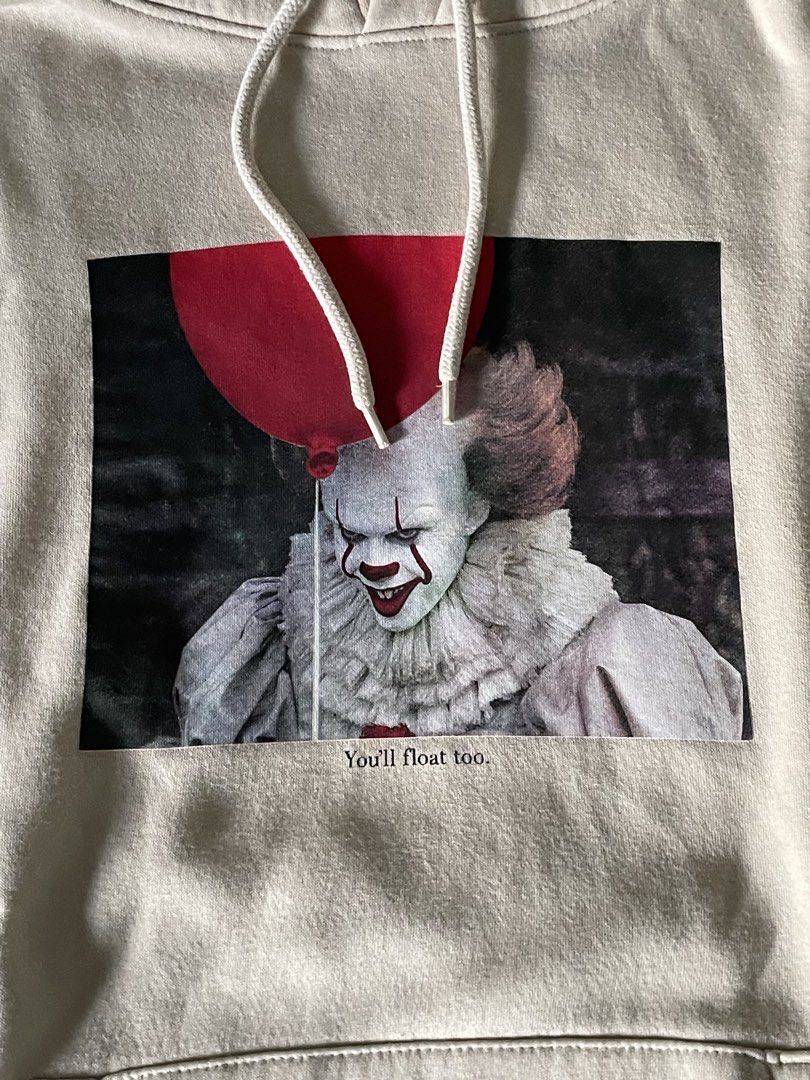 Divided Pennywise Hoodie (Category: Hoodies) located in Makati City. Submitted by things77 (Listing ID 1432505134, Image 2). Description: - Pennywise graphic hoodie - Features "You'll float too" phrase - Kangaroo pocket - Hood with drawstrings - Red "IT" symbols on sleeves - Size: M/S - Color: Light beige.