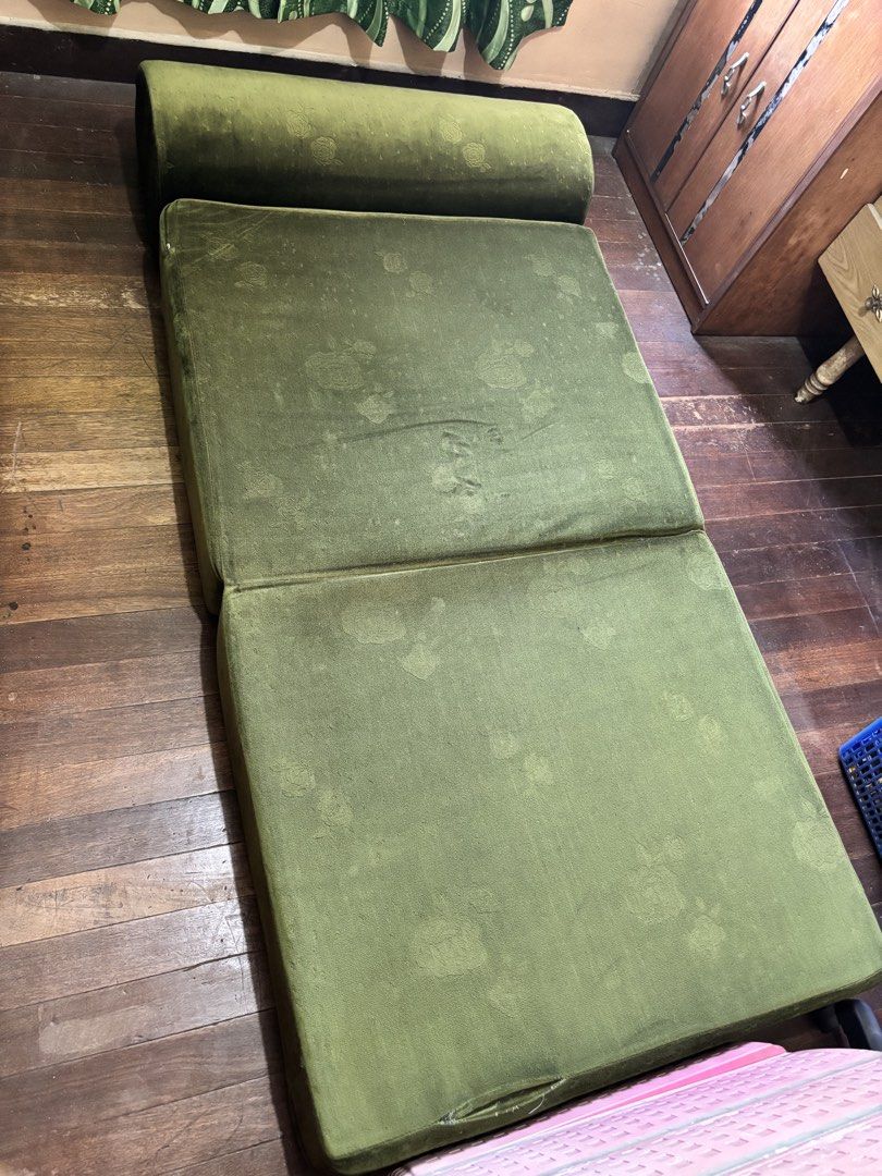 Foldable Green Sofa Bed (Category: Sofas) located in Quezon City. Submitted by chloe.w8 (Listing ID 1432403994, Image 2). Description: - Green floral patterned foldable sofa bed - Converts easily from sofa to bed - Bed dimensions: Approximately 190cm long, 36 inches wide - Features a rolled headrest when used as a sofa.