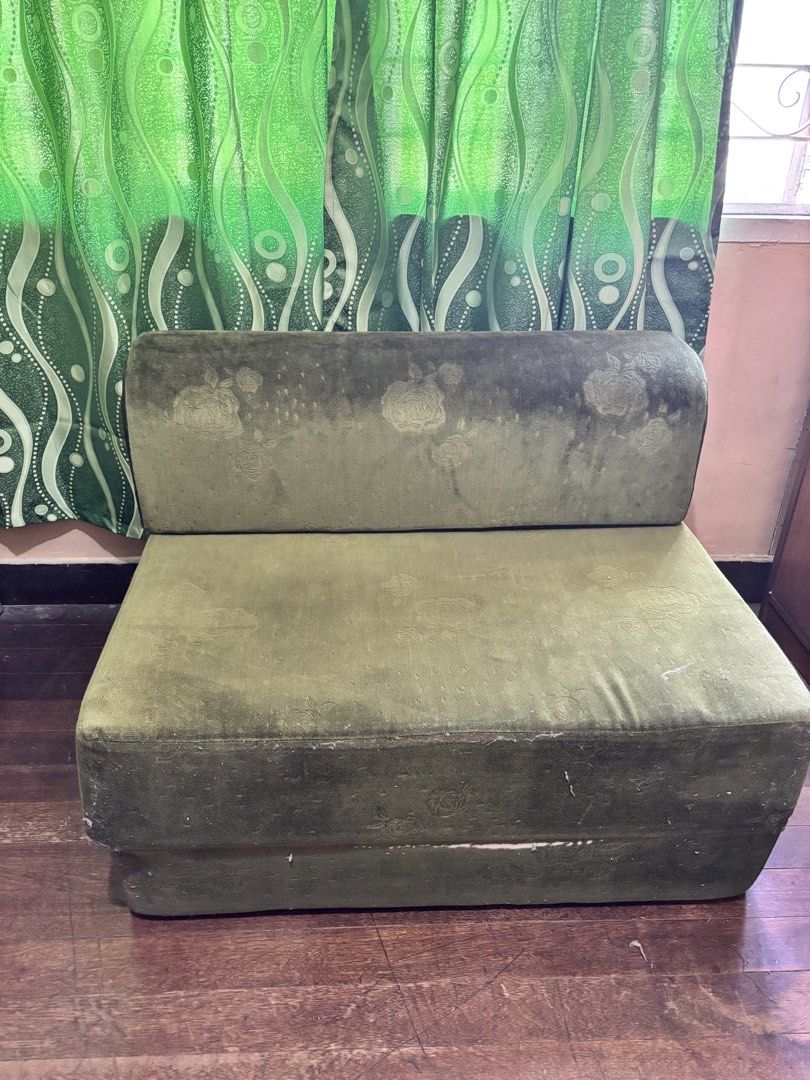 Foldable Green Sofa Bed (Category: Sofas) located in Quezon City. Submitted by chloe.w8 (Listing ID 1432403994, Image 3). Description: - Green floral patterned foldable sofa bed - Converts easily from sofa to bed - Bed dimensions: Approximately 190cm long, 36 inches wide - Features a rolled headrest when used as a sofa.
