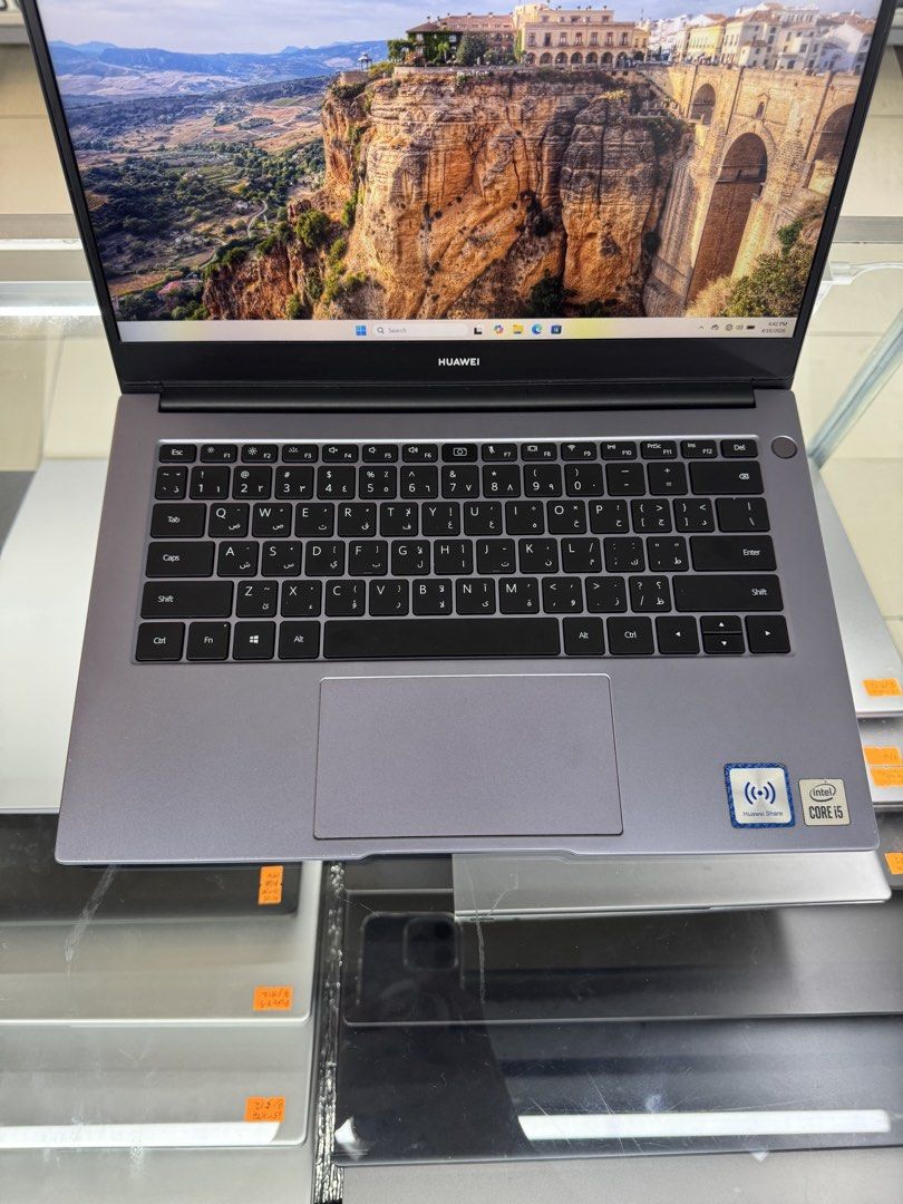 Huawei Laptop with Intel Core i5 (Category: Laptops & Notebooks) located in Manila. Submitted by oddlion-e6f6 (Listing ID 1432485939, Image 3). Description: - Huawei laptop with a sleek grey finish - Intel Core i5 processor - Arabic keyboard - Includes touchpad - Features Huawei Share sticker - Screen displays a scenic landscape - Huawei logo on the back .