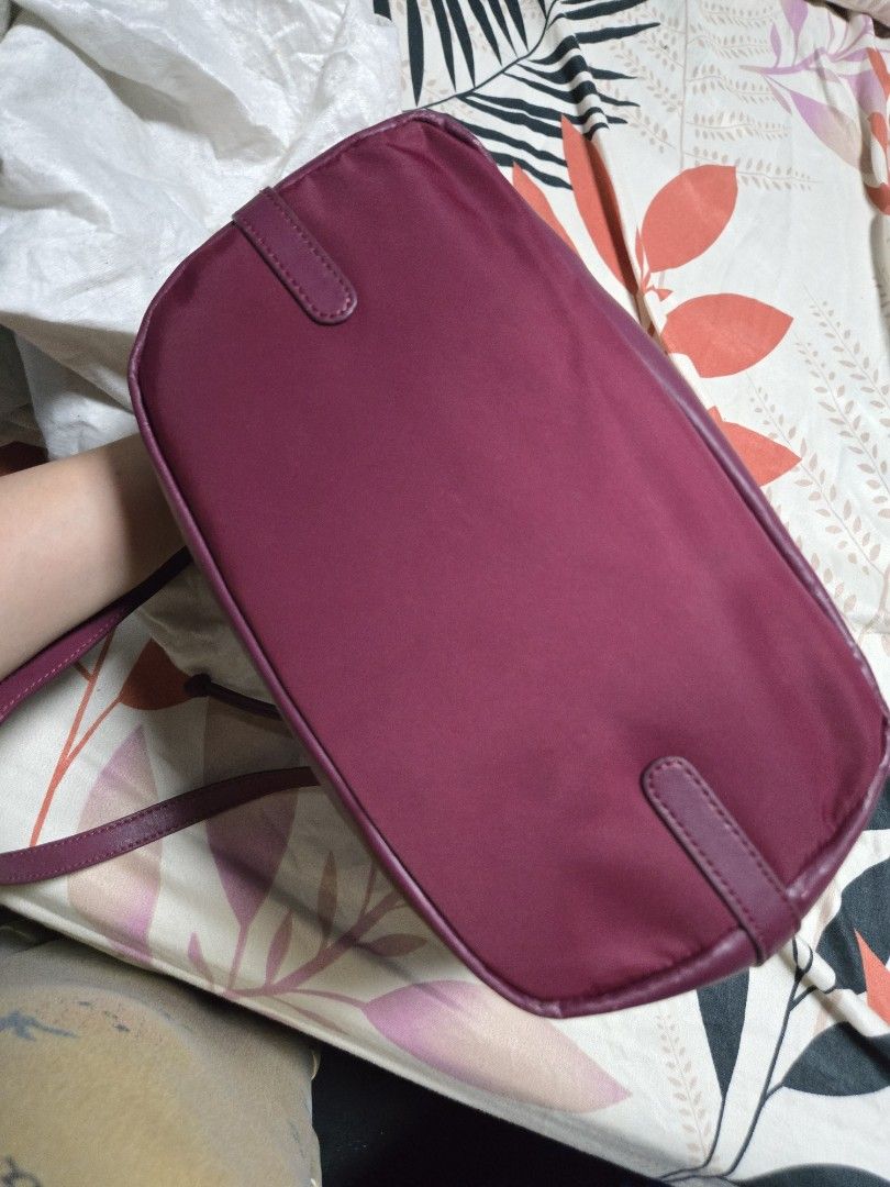 Kate Spade Drawstring Handbag (Category: Luxury Bags & Wallets) located in Bulacan. Submitted by row01 (Listing ID 1432558682, Image 3). Description: -Authentic - Kate Spade handbag - Drawstring closure - Shoulder strap - Deep burgundy exterior - Matching base and trim - Striped interior lining - Small zippered pocket inside - Includes Kate Spade dust bag -with some scratches as seen in the photo.