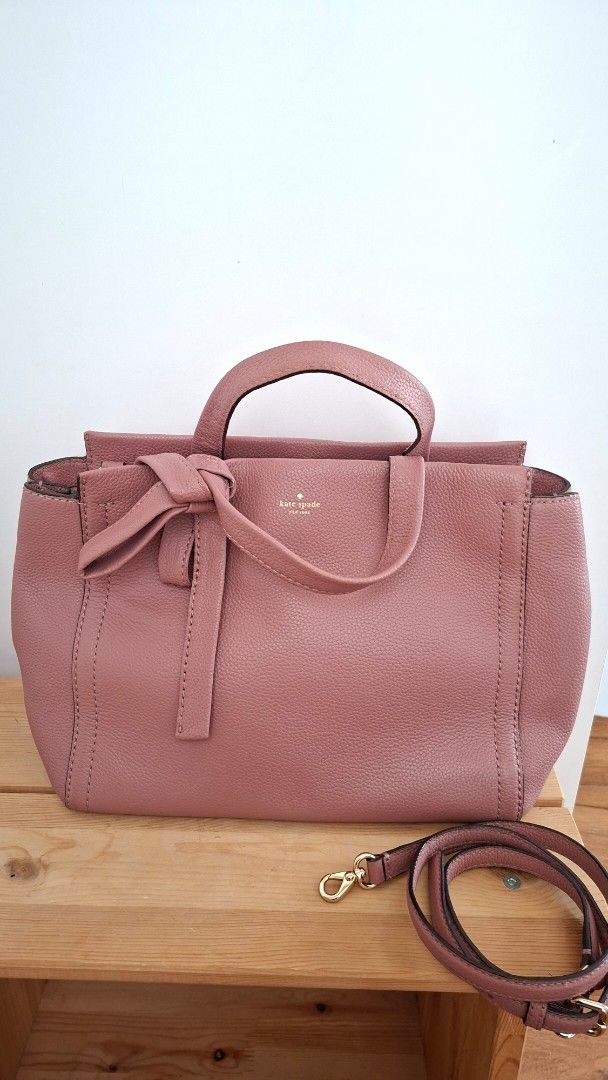 Kate Spade Pink Handbag with Shoulder Strap (Category: Luxury Bags & Wallets) located in Mandaluyong City. Submitted by lgonz (Listing ID 1432512176, Image 1). Description: - 100% Authentic; full leather - No issues, no scratches - Like new, gently used for about 3 times only - Beautiful pink color - Detachable shoulder strap - Top handle - Bow detail on the front - Patterned interior lining - Small interior pocket - Protective metal feet - Inclu