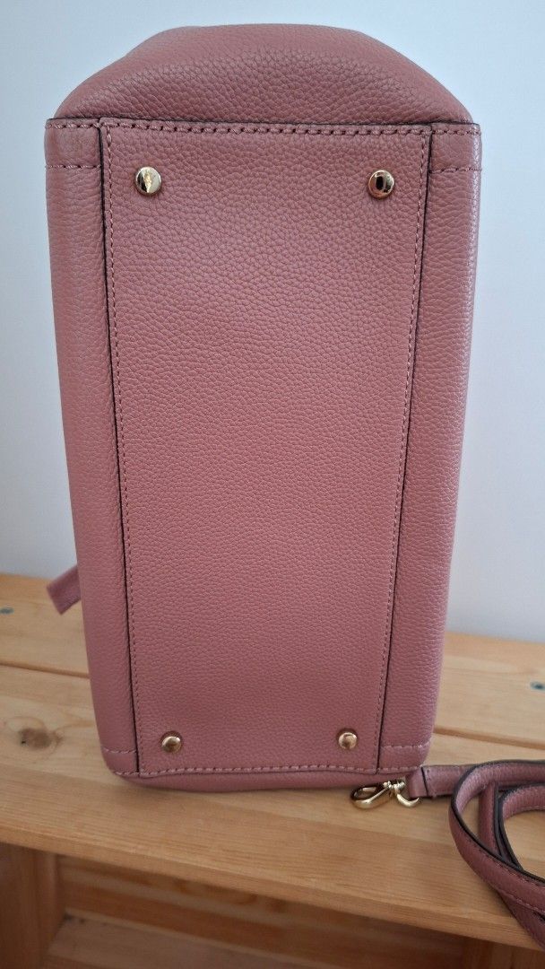 Kate Spade Pink Handbag with Shoulder Strap (Category: Luxury Bags & Wallets) located in Mandaluyong City. Submitted by lgonz (Listing ID 1432512176, Image 2). Description: - 100% Authentic; full leather - No issues, no scratches - Like new, gently used for about 3 times only - Beautiful pink color - Detachable shoulder strap - Top handle - Bow detail on the front - Patterned interior lining - Small interior pocket - Protective metal feet - Inclu