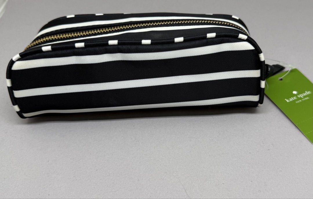 Kate Spade Small Berrite Cosmetic Bag (Category: Luxury Bags & Wallets) located in Quezon City. Submitted by d.othersetc (Listing ID 1432509142, Image 3). Description: - Authentic Kate Spade cosmetic bag - Black and white stripe design - Gold-toned zipper and hardware - Includes original tags with CAD and USD price - Black interior with care card - Small, rectangular shape.