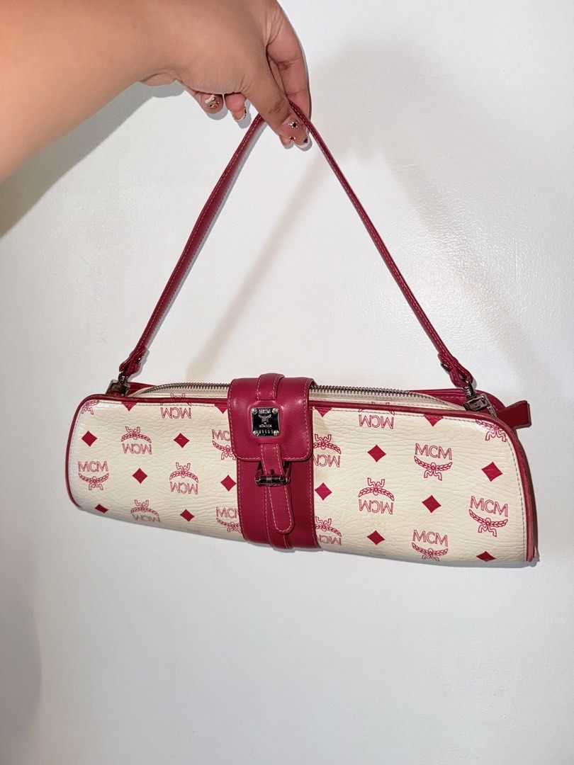 MCM Cylinder Handbag (Category: Luxury Bags & Wallets) located in Manila. Submitted by pink.lady_01 (Listing ID 1432437662, Image 1). Description: - Authentic MCM cylinder handbag - White and red color scheme with MCM logo pattern - Top handle - Zipper closure - Fabric lining - Small interior pocket - Buckle closure on front - Silver-toned hardware.
