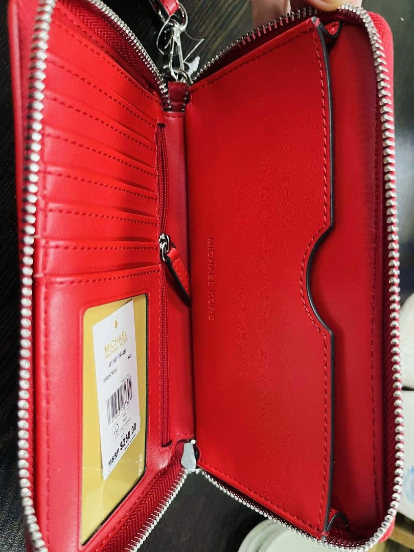 Michael Kors Red MK Print Wallet (Category: Wallets & Card holders) located in Pasig City. Submitted by stuffsnme (Listing ID 1432548516, Image 3). Description: - Michael Kors wallet with a striking red and white MK print. - Secure zip-around closure. - Convenient wrist strap for easy carrying. - Interior with multiple card slots and compartments for organization. - Features a stylish red leather stripe with the Michael Kors logo. - Includes the 