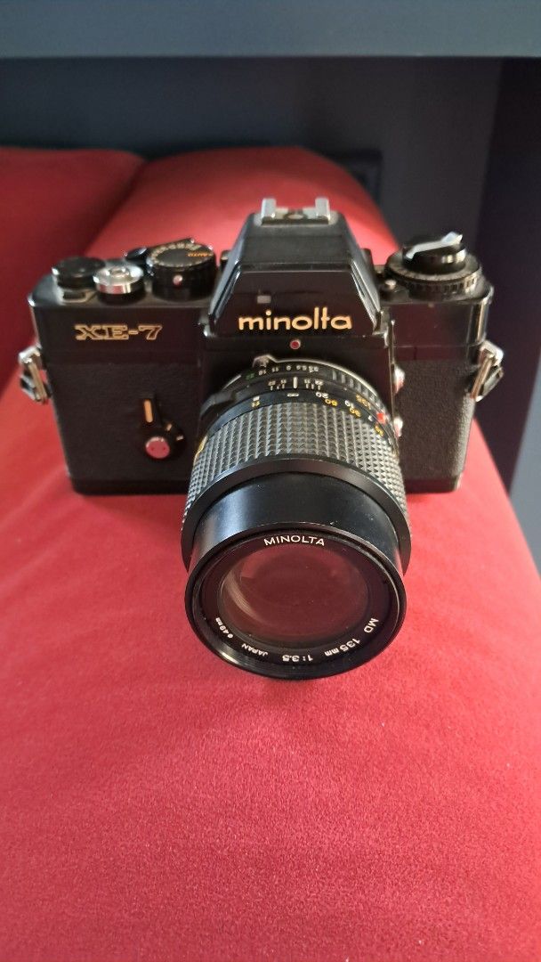 Minolta XE-7 Camera with Lens (Category: Cameras) located in Santa Rosa. Submitted by majanice (Listing ID 1432462865, Image 1). Description: - Minolta XE-7 SLR camera - Includes Minolta MD 135mm f/2.8 lens - Black camera body - Lens with focus ring and aperture settings condition untested for repair/ parts.