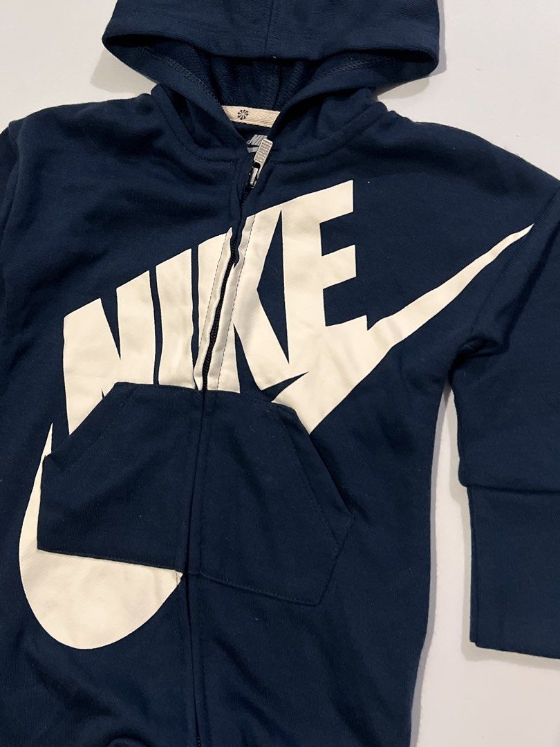 Nike Baby Romper with Hood (Category: Babies & Kids Fashion) located in Imus. Submitted by kidd0_666 (Listing ID 1432433883, Image 2). Description: - Navy blue Nike baby romper - Features a large white Nike logo - Includes a hood and front pocket - Full-length zipper for easy wear - Size: 12M (74-80cm) - Made in Vietnam.