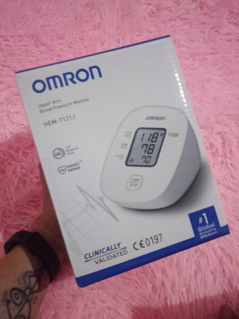Omron Upper Arm Blood Pressure Monitor HEM-7121J (Category: Health Monitors & Weighing Scales) located in Caloocan City. Submitted by arj2117 (Listing ID 1432420999, Image 1). Description: Omron Upper Arm Blood Pressure Monitor HEM-7121J. Features clinically validated accuracy. The device displays blood pressure readings on a digital screen. It is a global #1 brand. The box shows the device and its features. The device is designed for home use..