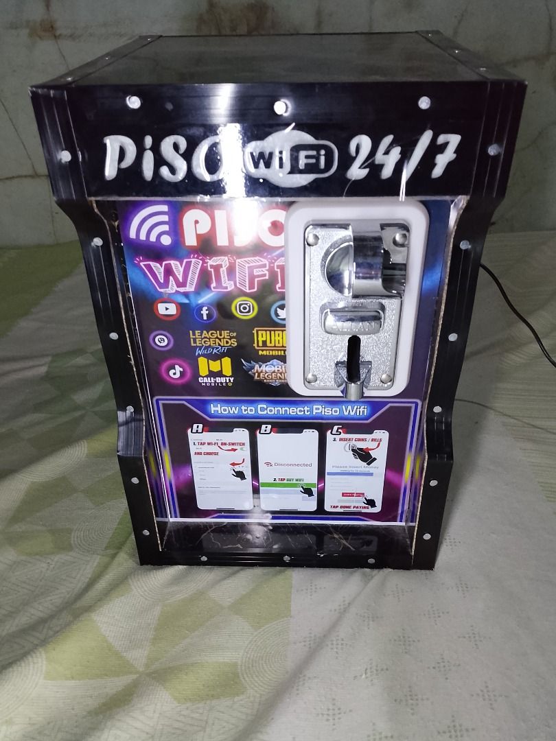 Piso Wifi 24/7 Machine ( issue lost key) (Category: Office & Business Technology) located in Caloocan City. Submitted by marius41 (Listing ID 1432397239, Image 1). Description: - 24/7 Piso Wifi access - Features a coin slot for easy payment - Clear display with connection instructions - Stylish black design with wooden back panel - Includes Piso Wifi logo and online game icons - Comes with a power cord for immediate use.