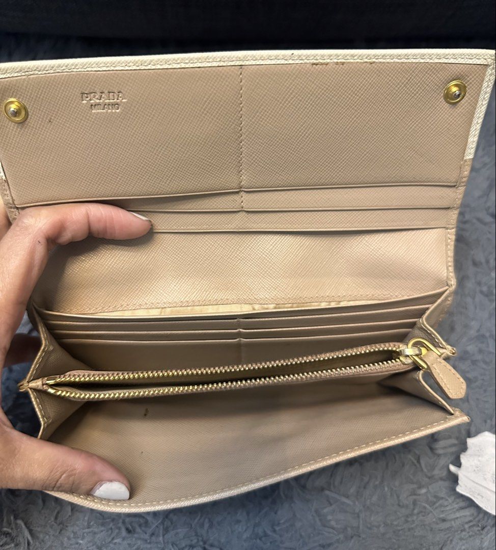 Prada Long Wallet (Category: Luxury Bags & Wallets) located in General Trias. Submitted by mimispreloves (Listing ID 1432557259, Image 3). Description: - Prada long wallet - Bi-color design: beige and cream - Multiple card slots - Compartments for organization - Zippered coin pocket - Made of leather - Prada logo on front - Snap closure - Gold-tone hardware -Php5k only .