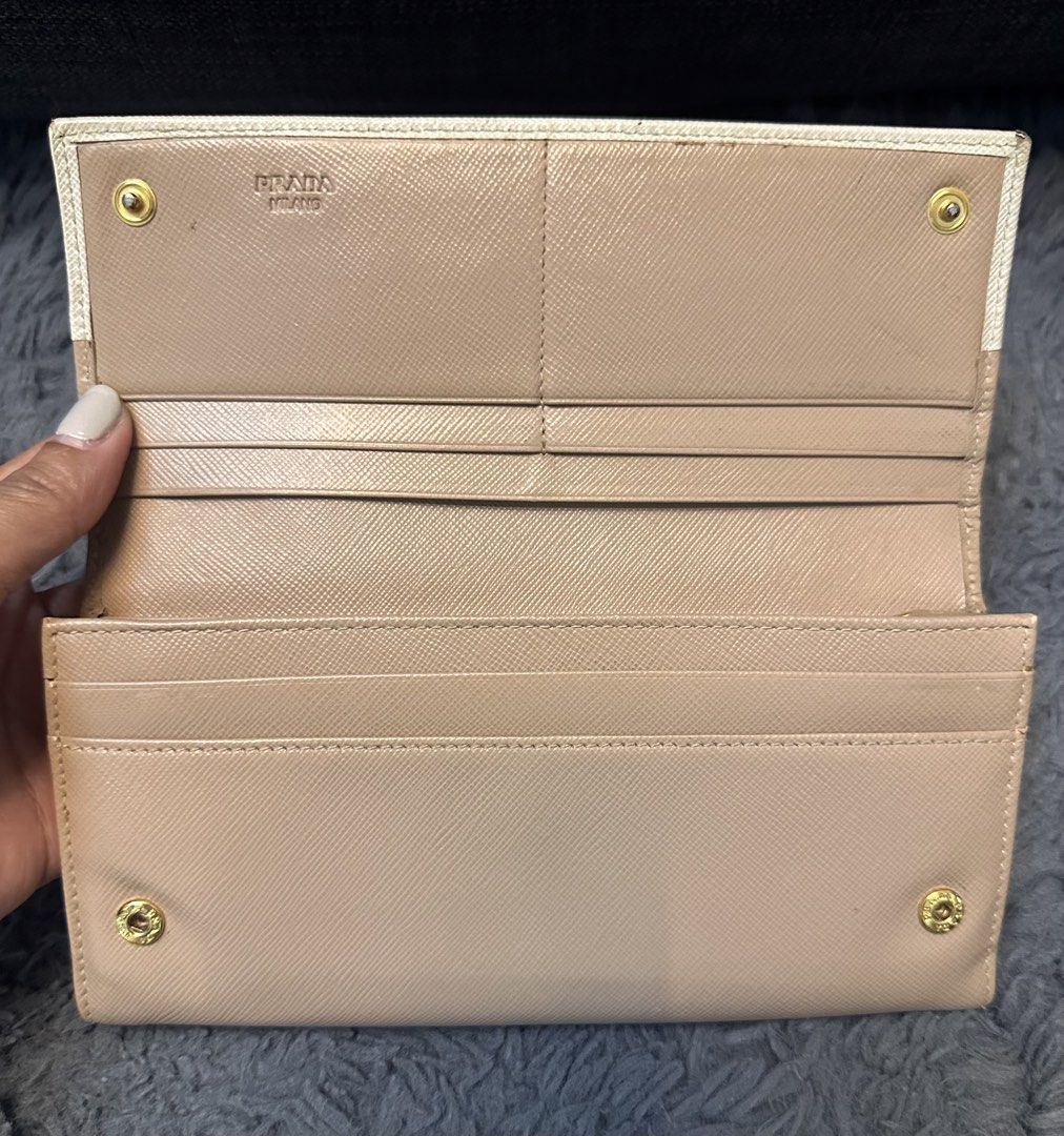 Prada Long Wallet (Category: Luxury Bags & Wallets) located in General Trias. Submitted by mimispreloves (Listing ID 1432557259, Image 2). Description: - Prada long wallet - Bi-color design: beige and cream - Multiple card slots - Compartments for organization - Zippered coin pocket - Made of leather - Prada logo on front - Snap closure - Gold-tone hardware -Php5k only .
