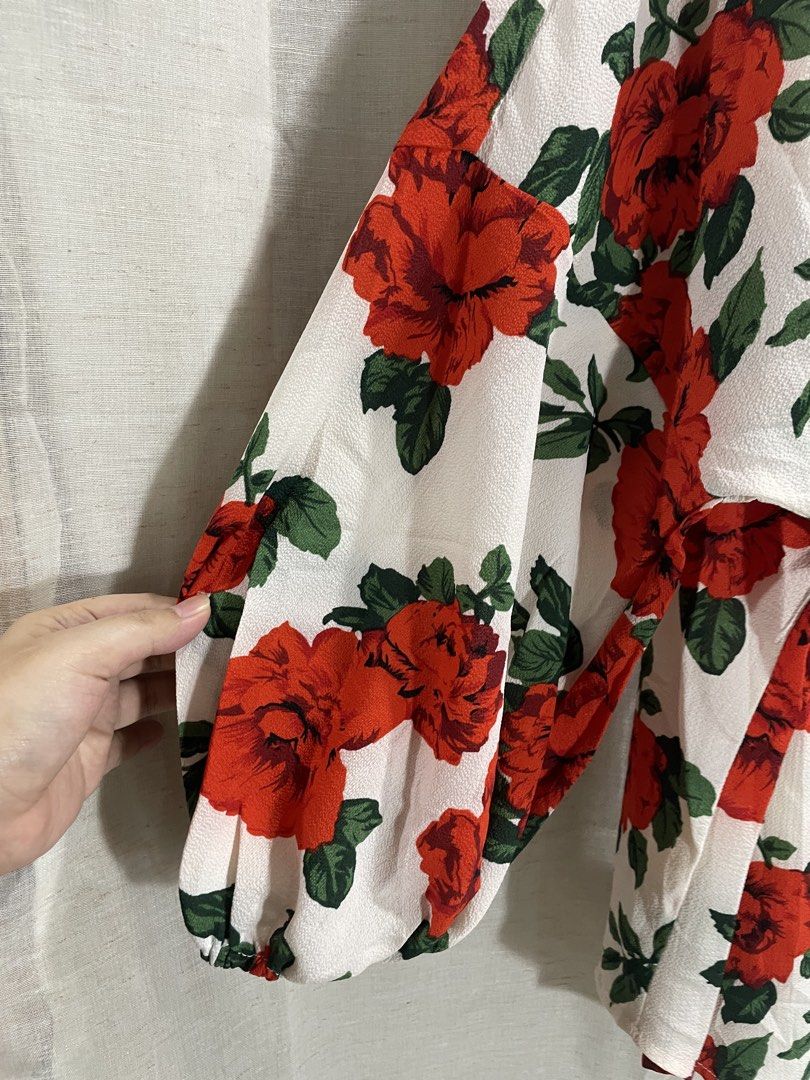 SHEIN Floral Wrap Blouse 2XL (Category: Blouses) located in Quezon City. Submitted by 27ValiantStreet_Storefront (Listing ID 1432499177, Image 3). Description: - SHEIN floral wrap blouse - Size: 2XL - Design: Red rose print on white background - Features: Long sleeves, wrap design with tie closure - Origin: Made in China.