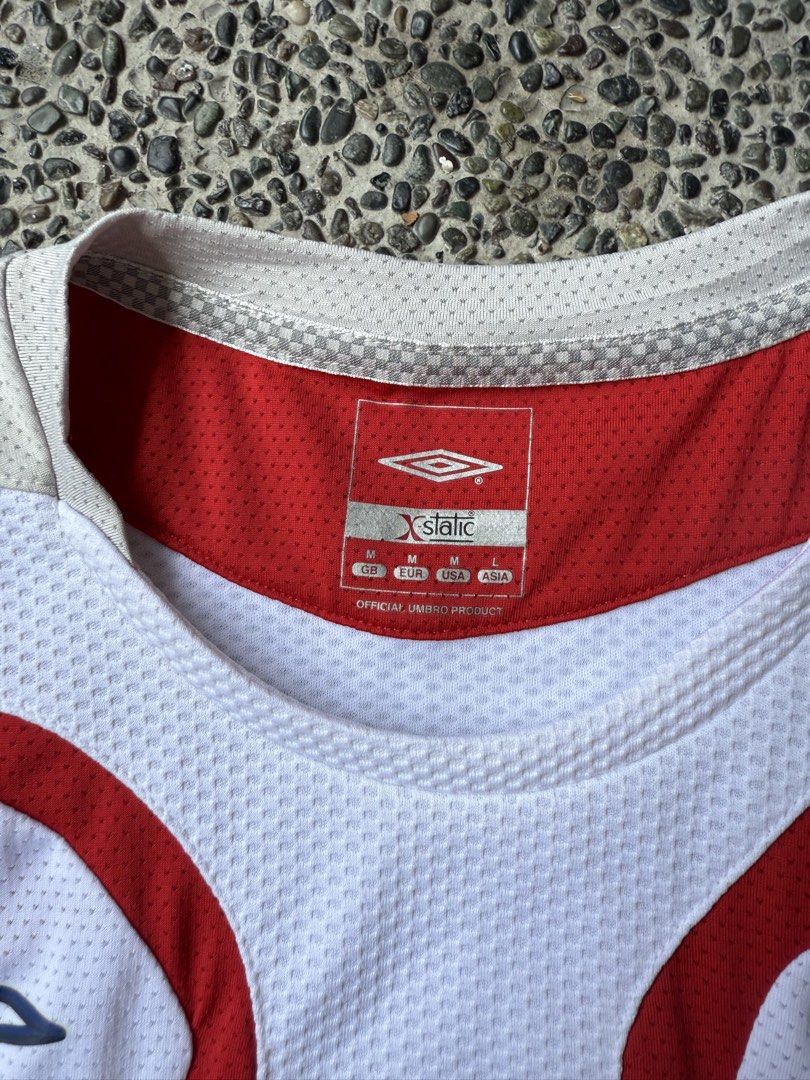 Umbro England National Team Jersey (Category: Tshirts & Polo Shirts ) located in Dinalupihan. Submitted by thrift.trips (Listing ID 1432564029, Image 3). Description: - Official England Umbro jersey - Size: M - Color: White with red accents - Material: Polyester and nylon - Features: England crest, Umbro logo, X-Static tag - Length 29 - Width 20.5.