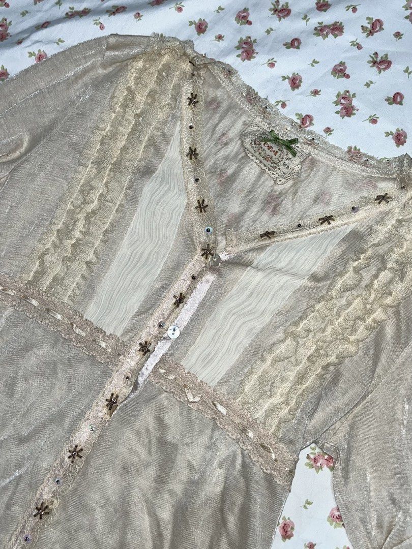 Vintage Beige Blouse with Lace Details (Category: Blouses) located in Pasay City. Submitted by prettiest_girl_in_the_world (Listing ID 1432437459, Image 2). Description: - Vintage beige blouse - Intricate lace and ruffle detailing - V-neckline - Long sleeves - Decorative embellishments - Semi-sheer fabric - Perfect for vintage-inspired looks.