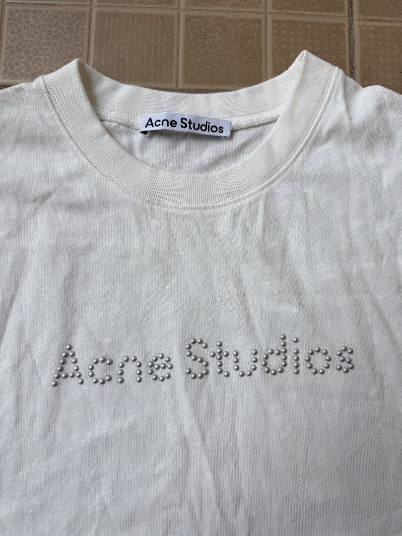 Acne Studios Studded Logo T-shirt (Category: Tshirts & Polo Shirts ) located in Legazpi City. Submitted by tiny0509 (Listing ID 1432661544, Image 2). Description: - Acne Studios cream t-shirt - Studded logo - Crew neck, short sleeves - Size M - Made in Portugal - 100% cotton 22x29 dimes - Production year: 2022.