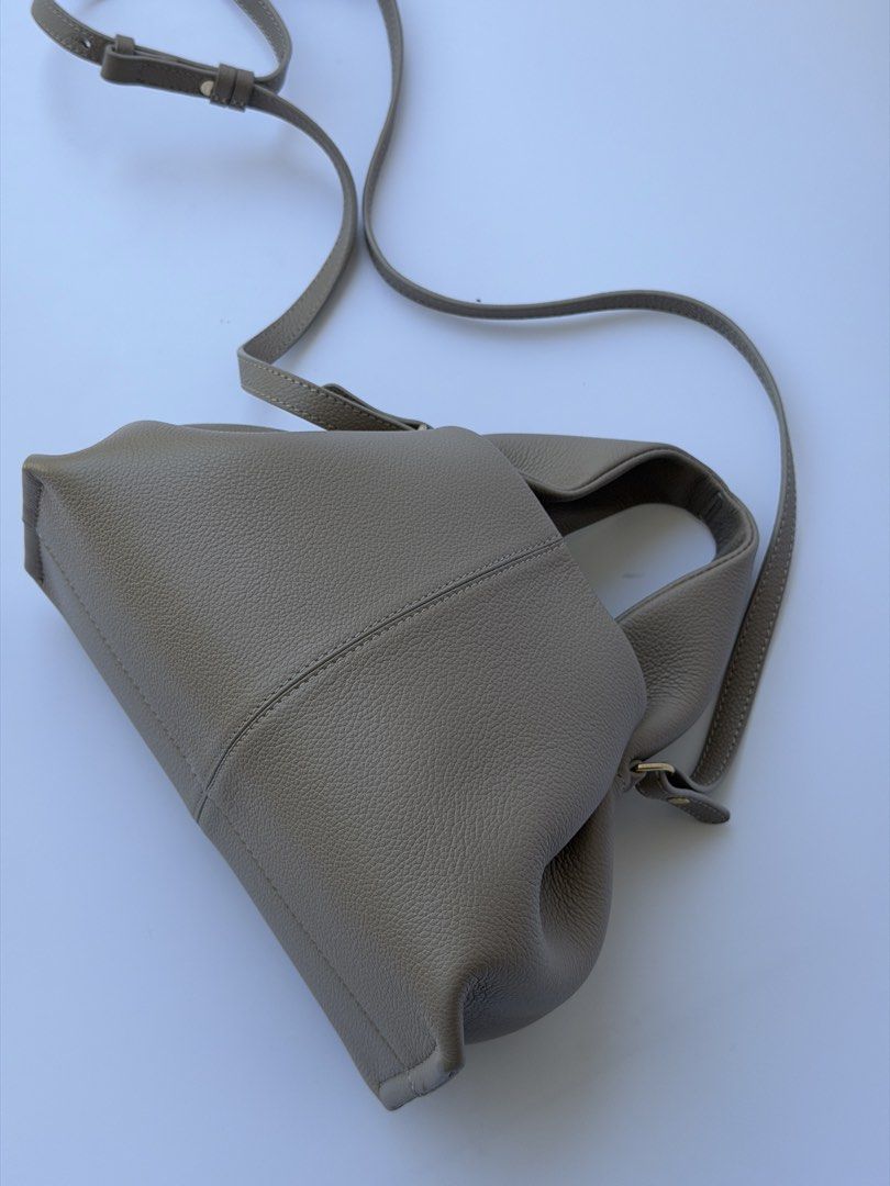 AUTHENTIC The Polène Numéro Neuf Mini in textured beige leather is a luxury crossbody bag (Category: Shoulder Bags) located in Rizal. Submitted by lovelyscloset (Listing ID 1432700639, Image 3). Description: Taupe handbag with gathered design. Features top handle and detachable strap. Textured leather, structured base, and magnetic closure. Stylish stitching..