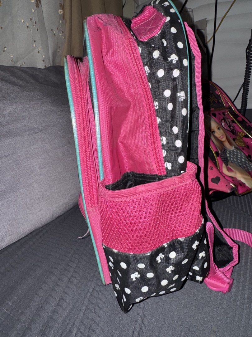 Barbie Squad Goals Backpack (Category: Babies & Kids Fashion) located in Paranaque City. Submitted by ledzai (Listing ID 1432630204, Image 2). Description: - Barbie backpack with a fun pink and black polka dot design. - Features "Barbie Squad Goals" graphics. - Multiple compartments for storage, including a front pocket and side pockets. - Pink interior. - Adjustable straps for a comfortable fit. - Adorned with Barbie logo zipper charms. - Ideal 