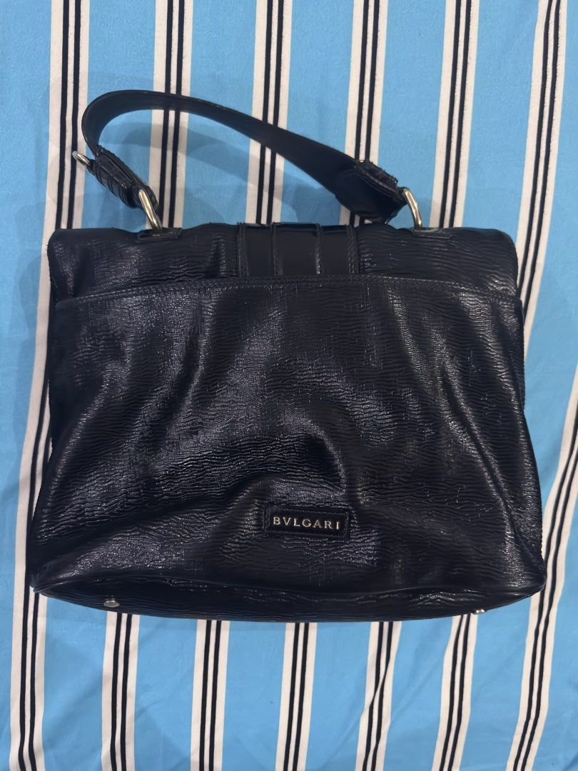Bvlgari Black Leather Handbag (Category: Luxury Bags & Wallets) located in Dagupan City. Submitted by pardonmyfrench2025 (Listing ID 1432651392, Image 2). Description: - Authentic Bvlgari handbag - Black leather exterior - Unique lion head clasp - Top handle design - Interior lined with light green fabric - Includes zippered pocket - Textured exterior - Bvlgari logo on the back - Made in Italy.