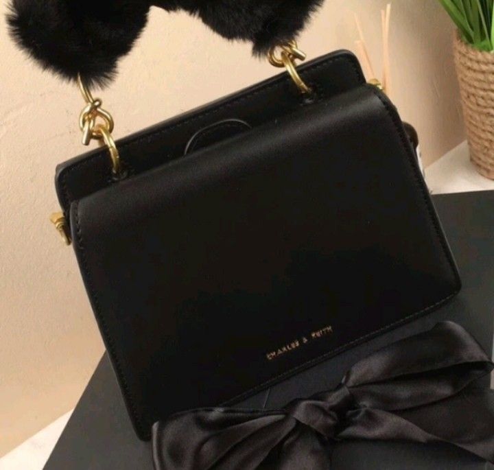 Charles & Keith Black Handbag with Fur Handle (Category: Shoulder Bags) located in Quezon City. Submitted by legitonly420 (Listing ID 1432619357, Image 2). Description: - Charles & Keith black handbag - Features a top handle with fur detailing - Includes a detachable shoulder strap - Adorned with a decorative black ribbon - Rectangular shape - Gold-colored hardware - Comes with original box.